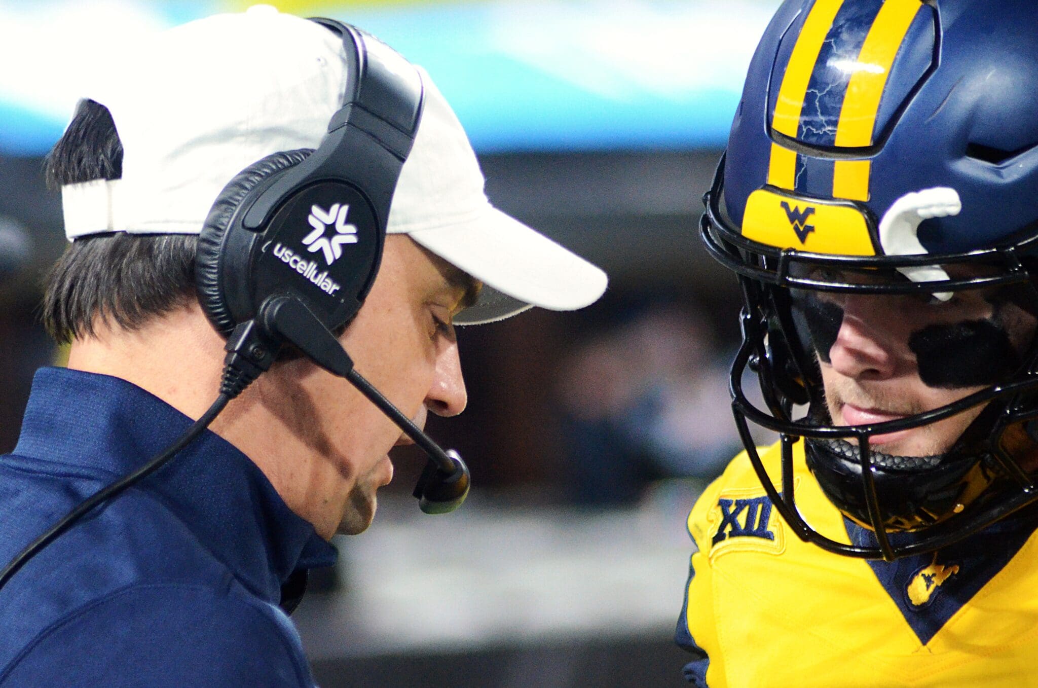 WVU quarterback Garrett Greene talks to head coach Neal Brown before taking the field against UNC in the Duke's Mayo Bowl at Bank of America Stadium in Charlotte, N.C. on Dec. 27, 2023. (Mitchell Northam / WV Sports Now)