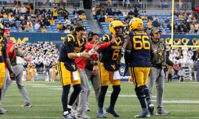 WVU Football Nicco Marchiol, Ryder Burton and Ja'Quay Hubbard celebrate touchdown on sidelines