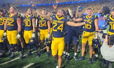 WVU Football players with Rodney Gallagher in front celebrating after beating Pitt in Backyard Brawl