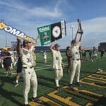WVU Baseball celebrating Super Regional title with sign and trophy