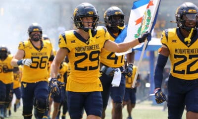 WVU Football Preston Fox carrying flag