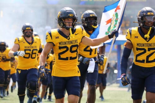 WVU Football Preston Fox carrying flag