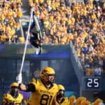 WVU Football TE Treylan Davis holding flag