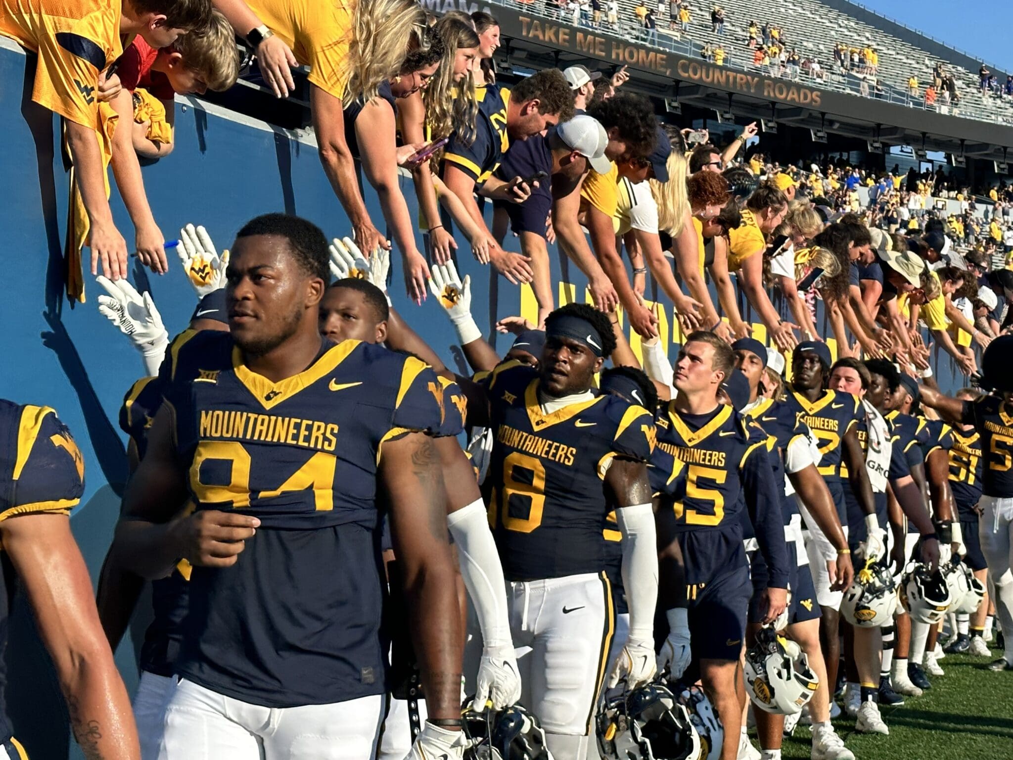 WVU Football players with fans during Country Roads