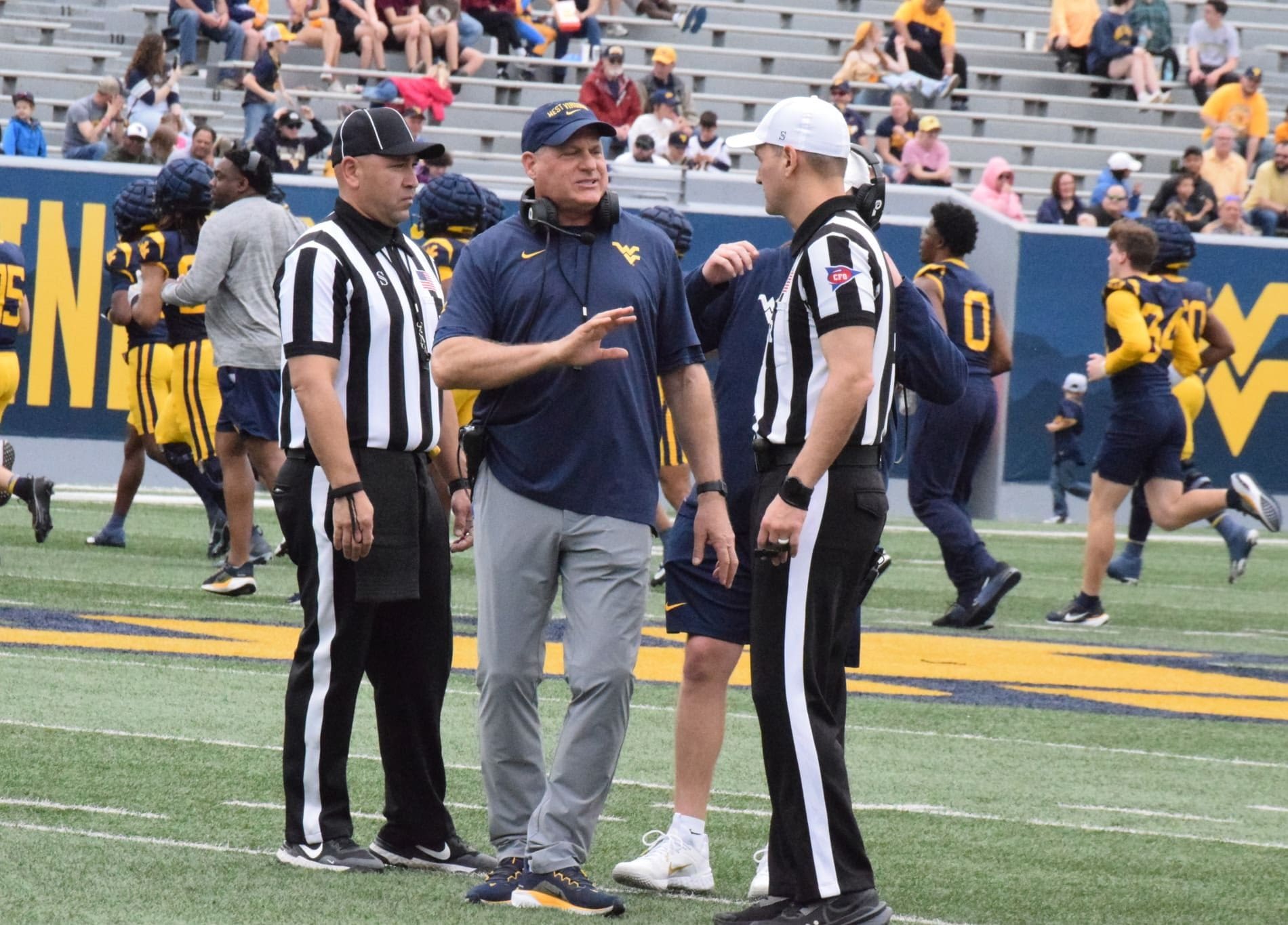 WVU Football HC Rich Rodriguez with refs during Spring Showcase