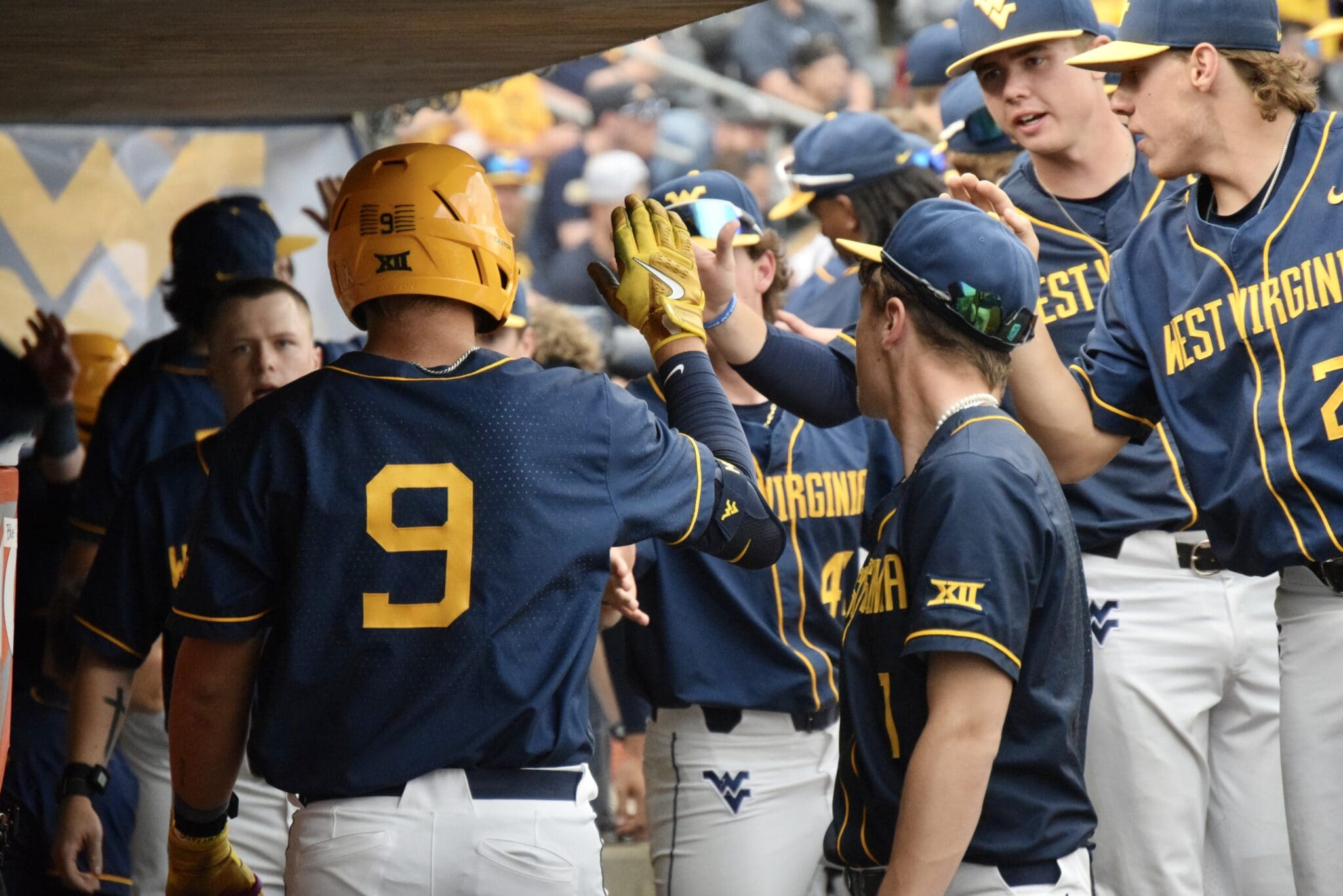 WVU Baseball Grant Hussey high fives teammates