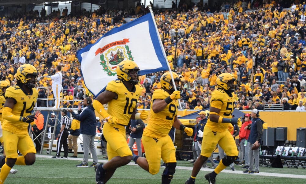 WVU Football carrying flag