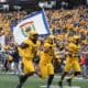 WVU Football carrying flag