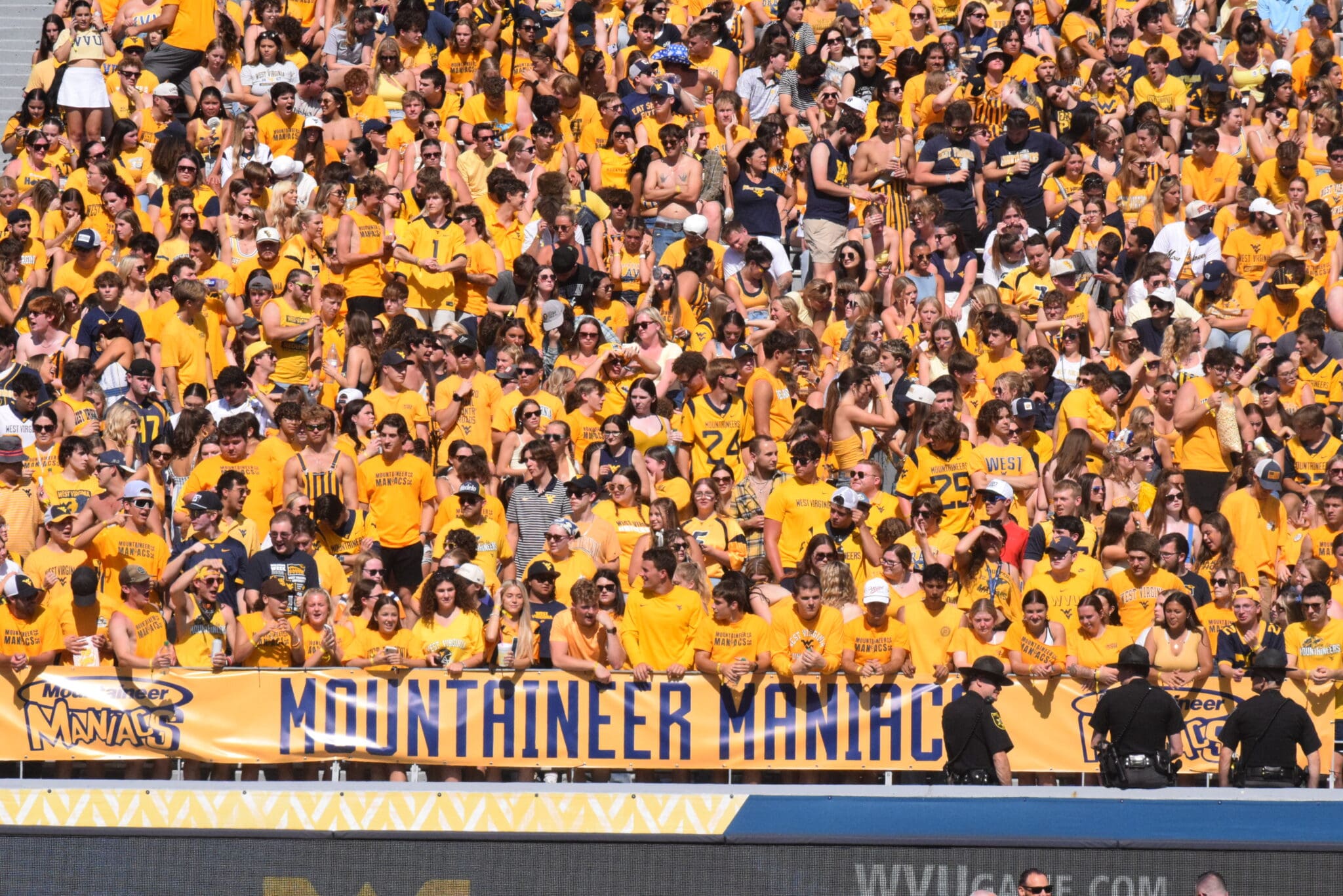 WVU Football fans in student section with Mountaineer Maniacs sign STOCK