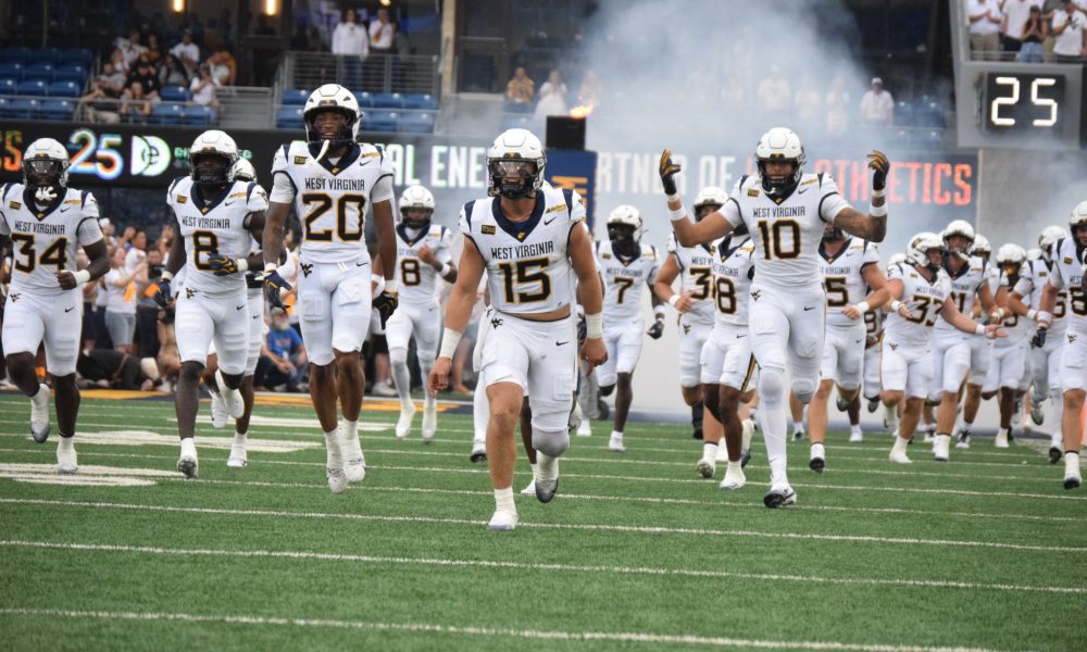 WVU Football team running out of tunnel stock