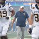 WVU Football HC Rich Rodriguez in between players