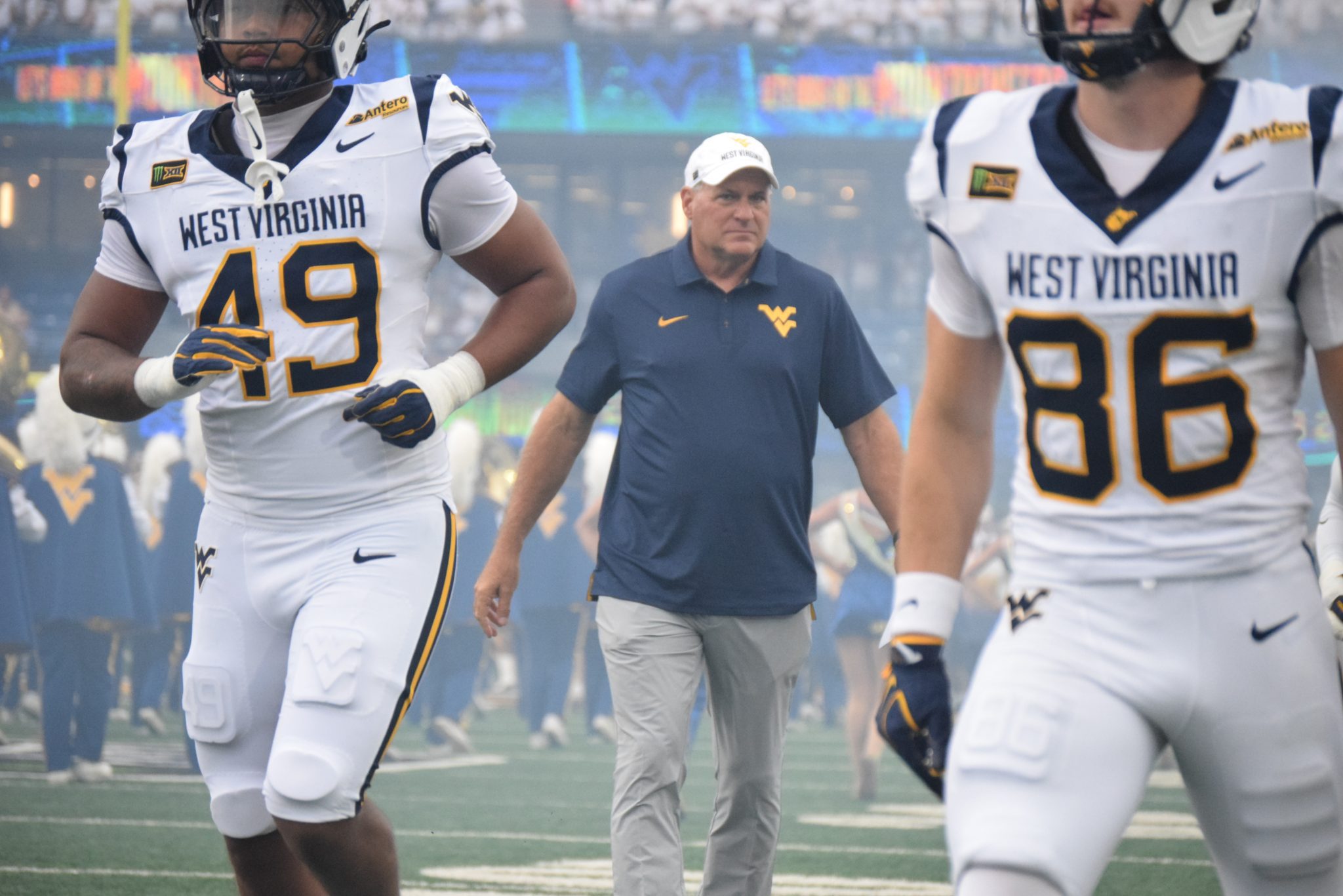 WVU Football HC Rich Rodriguez in between players