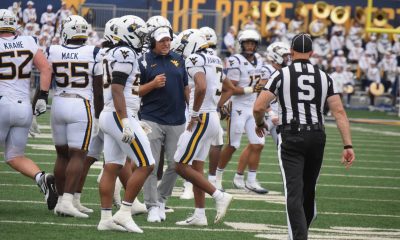 WVU Football HC Rich Rodriguez in huddle with players and Michael Hawkins