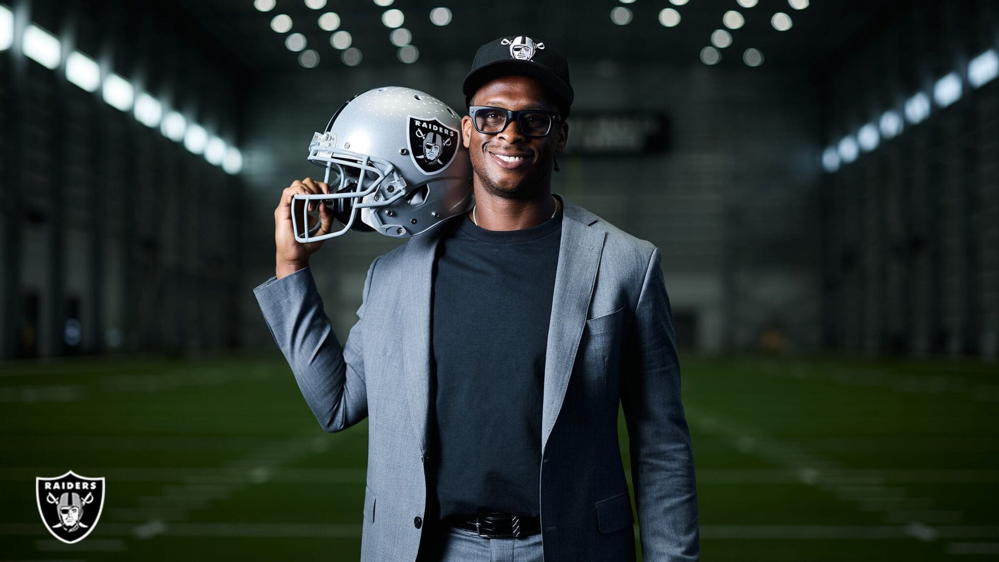 Geno Smith holding Raiders jersey