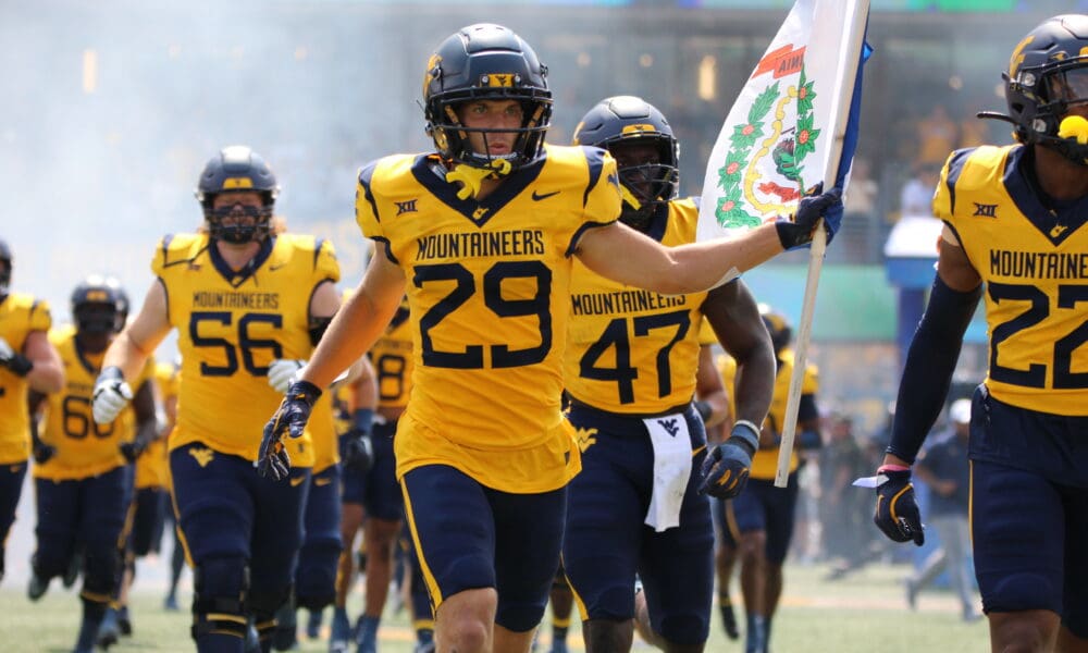 WVU Football Preston Fox carrying flag