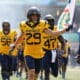 WVU Football Preston Fox carrying flag