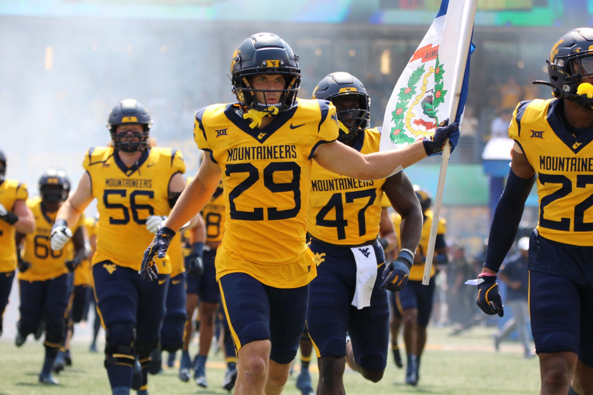 WVU Football Preston Fox carrying flag