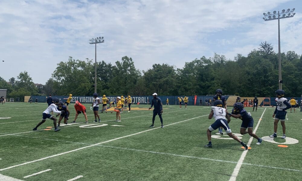 WVU Football WR Coach Bilal Marshall runs a drill during fall camp practice