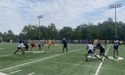 WVU Football WR Coach Bilal Marshall runs a drill during fall camp practice