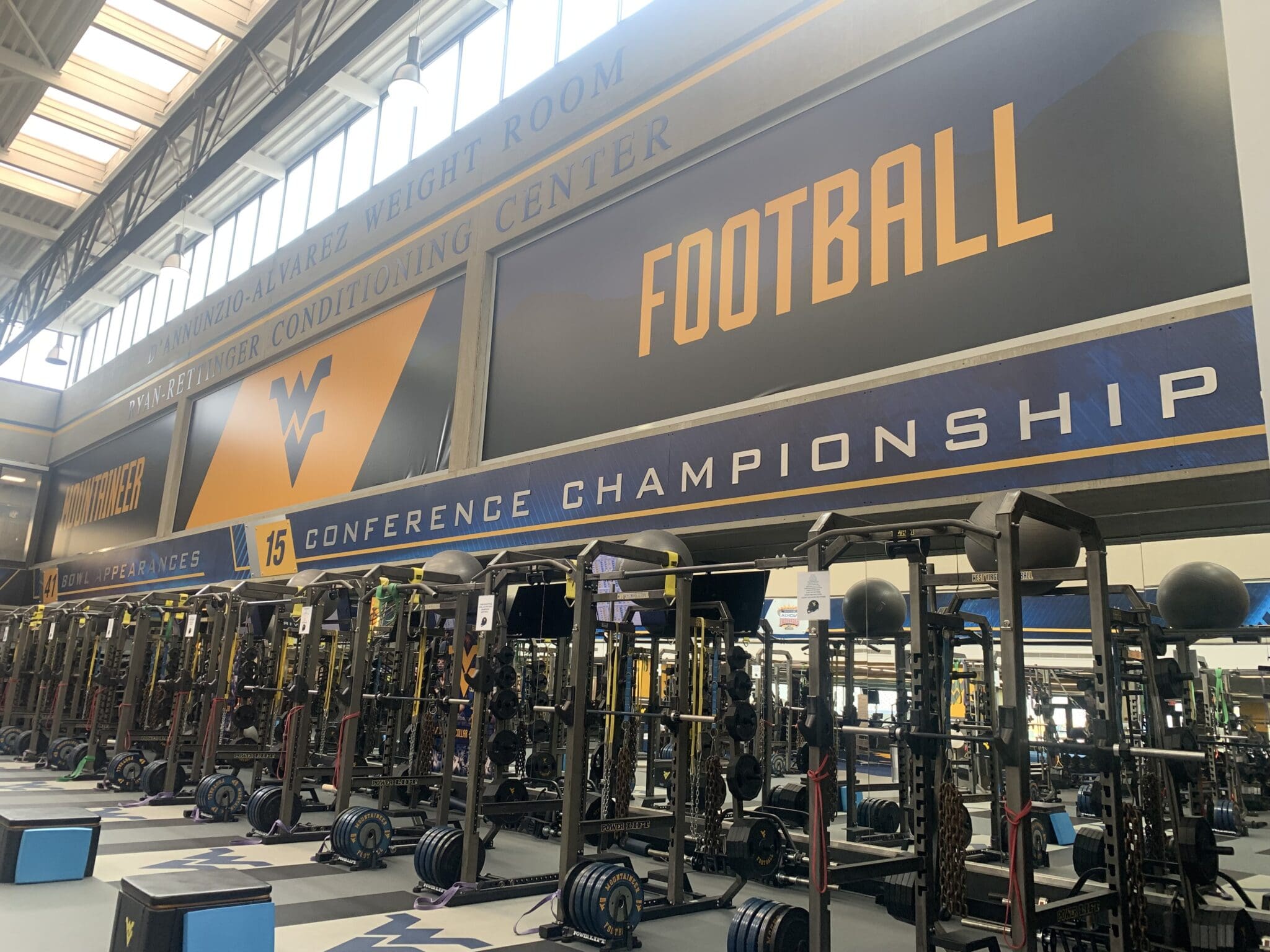 WVU Football conference titles on wall of weight room stock