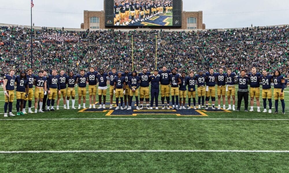 Notre Dame players and coaches on field