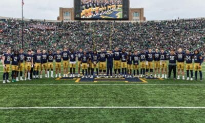 Notre Dame players and coaches on field