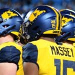 WVU huddles before lining up against UNC in the Duke's Mayo Bowl at Bank of America Stadium in Charlotte, N.C. on Dec. 27, 2023. (Mitchell Northam / WV Sports Now)
