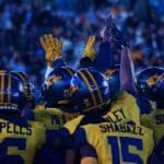 WVU Football players huddle up before the fourth quarter against UNC at the Duke's Mayo Bowl on Dec. 27, 2023, at Bank of America Stadium in Charlotte, N.C. (Mitchell Northam / WV Sports Now)