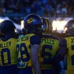 WVU Football players huddle up before the fourth quarter against UNC at the Duke's Mayo Bowl on Dec. 27, 2023, at Bank of America Stadium in Charlotte, N.C. (Mitchell Northam / WV Sports Now)