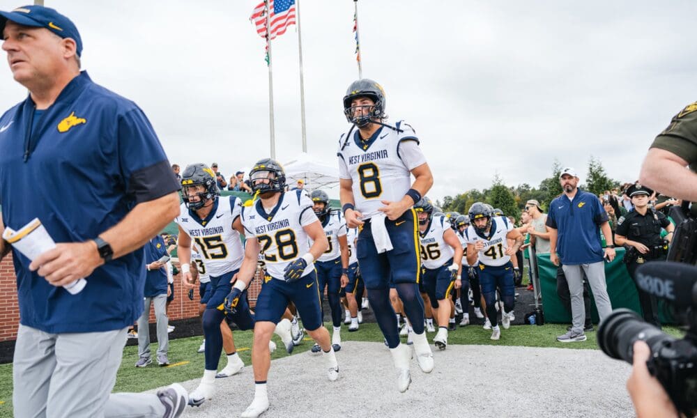 WVU Football HC Rich Rodriguez and Nicco Marchiol lead team on field at Ohio